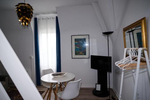 un soggiorno bianco con tavolo e letto di Les Salins de Batz-sur-mer a Batz-sur-Mer