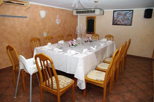 a dining room with a white table and chairs at Hotel Helena in Rokytnice nad Jizerou
