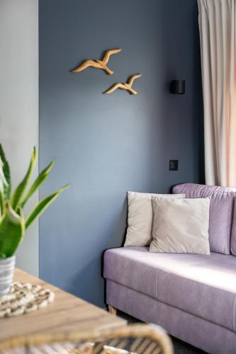 two birds flying above a couch in a living room at Przystań Stegna in Stegna