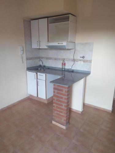 an empty kitchen with a counter and a sink at Dpto 1 dorm Parque Avalos in Resistencia