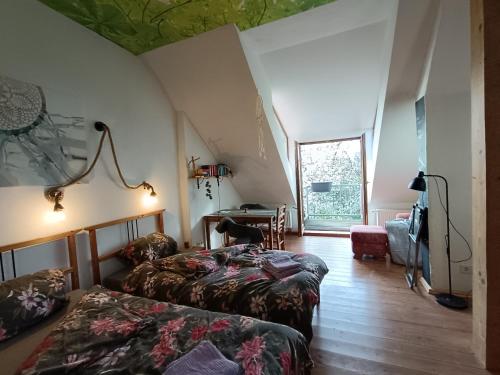 a attic room with two beds and a window at RuheOase mit Baumkronenblick in Naundorf