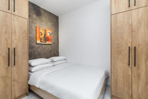 een slaapkamer met een bed en houten kasten bij Affogato by halu!: Bright and modern apartment in Thessaloniki