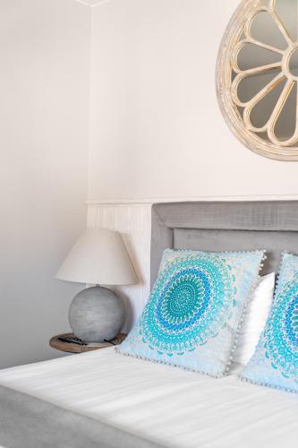 a bed with blue and white pillows and a lamp at Przystań Stegna in Stegna