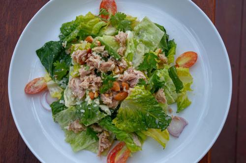 a salad on a white plate on a table at PIDA COFFEE FARM LODGE in Phumĭ Pu Pal