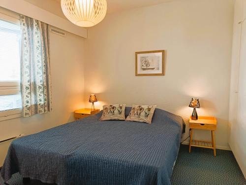 a bedroom with a bed with two lamps and a window at Näköalahuoneisto 324 in Syöte