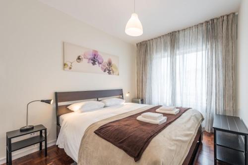 a bedroom with a large bed with two towels on it at GuestReady - Greatful Gaia in Vila Nova de Gaia