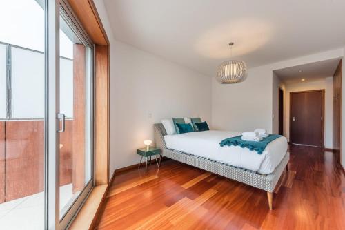 - une chambre avec un lit et une grande fenêtre dans l'établissement GuestReady - Jazz Apartment, à Porto