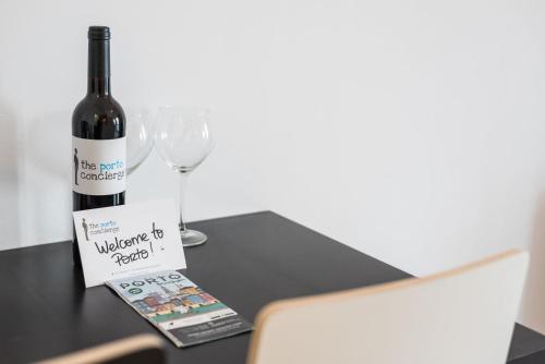 una bottiglia di vino seduta su un tavolo con un bicchiere di GuestReady - Music Flats 2 a Porto