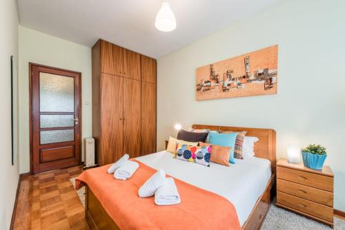 1 dormitorio con 2 camas con almohadas de color naranja en GuestReady - Sweet & Relax Flat, en Oporto