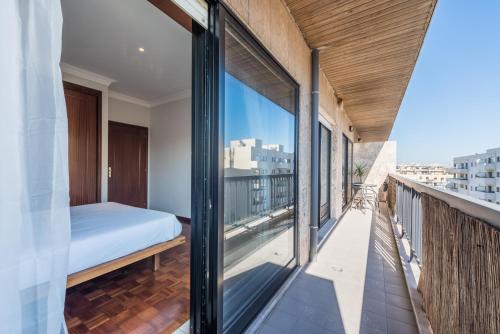 a bedroom with a bed on a balcony at GuestReady - Back to Tullins in Leça da Palmeira