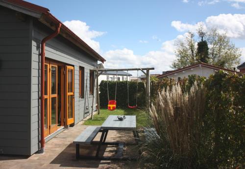 a backyard with a picnic table and a house at Villa Emilia - Gemütliches kinderfreundliches Blockhaus mit umzäuntem Garten in Sint Annaland