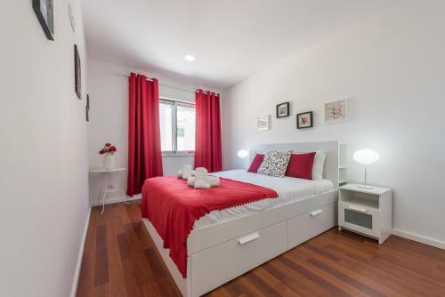 ポルトにあるGuestReady - Beautiful Plateauのベッドルーム1室(赤いカーテン、赤い毛布付きのベッド1台付)