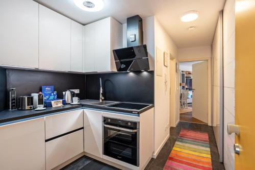 a kitchen with white cabinets and a stove top oven at Zentrale Ferienwohnung mit Balkon in Bad Liebenzell
