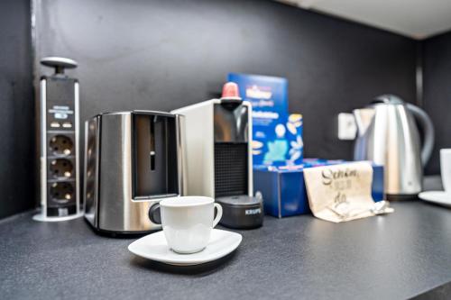 a coffee cup sitting on a counter with a coffee maker at Zentrale Ferienwohnung mit Balkon in Bad Liebenzell