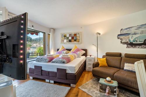 a bedroom with a bed and a couch at Zentrale Ferienwohnung mit Balkon in Bad Liebenzell