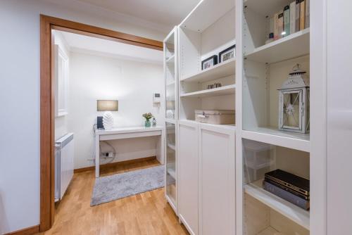 ポルトにあるGuestReady - Amaryllis Apartmentの白い棚とデスクが備わる部屋
