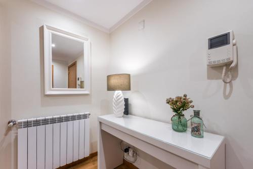 ポルトにあるGuestReady - Amaryllis Apartmentの白いラジエーターと鏡が備わる白い部屋