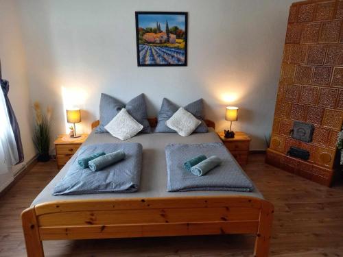 a bedroom with a wooden bed with pillows on it at Vidám ház, a Zöld Szívü faluban Sopron mellett in Sopronkövesd
