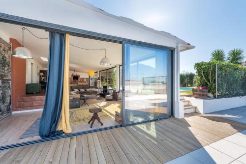 a house with large sliding glass doors on a deck at GuestReady - Sunset Pool House in Esposende