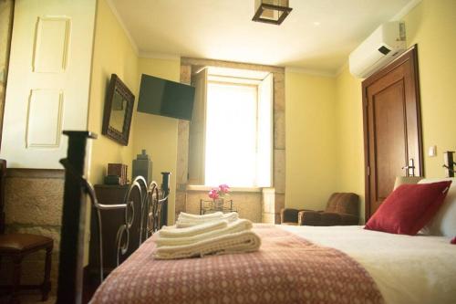 a bedroom with a bed with towels on it at Cosy Historical House in Lamego - Quinta do Cabo in Lamego