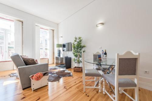 a living room with a glass table and chairs at GuestReady - Coral Apartment in Porto