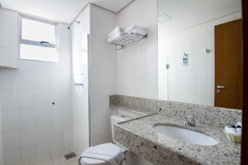 uma casa de banho com um lavatório e um WC em Hotel Atlas em Sete Lagoas