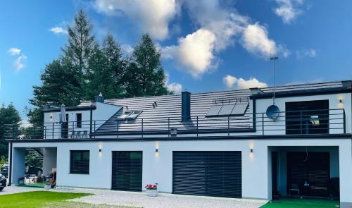 a white house with garage doors and a roof at RADO Aparts in Lądek-Zdrój