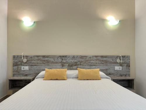 ロザスにあるAgi Llotja Plazzaのベッドルーム1室(大型ベッド1台、黄色い枕2つ付)