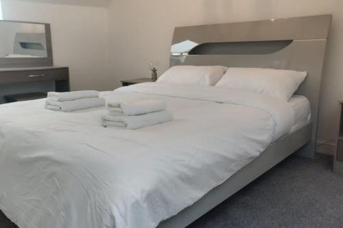 a large white bed with white sheets and pillows at Large 6 Bedroom house in Hendon in Hendon