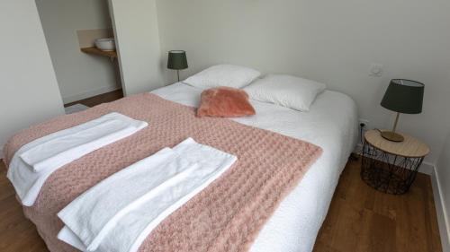 1 dormitorio con 1 cama con 2 toallas en Les gîtes du Haut Pin, en Calorguen