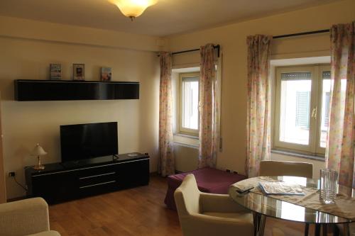 a living room with a table and a television at Casa Paolina in Lucca