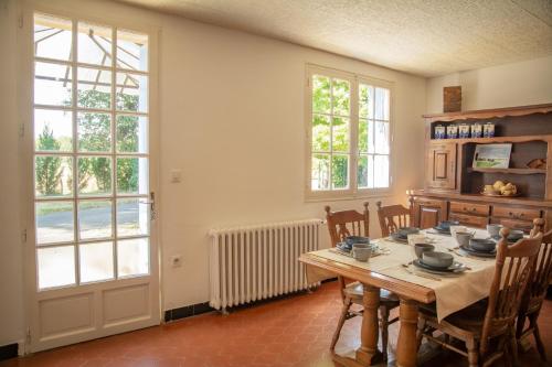 d'une salle à manger avec une table et quelques fenêtres. dans l'établissement La Caillade, à Bayac