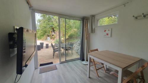 d'une salle à manger avec une table et une porte coulissante en verre. dans l'établissement Lacustrebnb, à Choisy