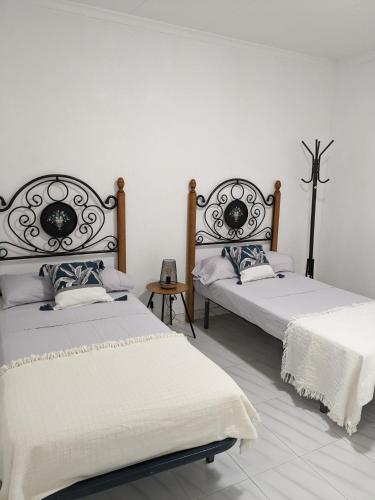 - 2 lits dans une chambre aux murs blancs dans l'établissement ALCANAR DEL MAR, à Les Cases d'Alcanar