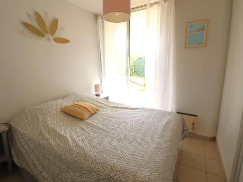 une chambre avec un lit avec un oreiller dessus dans l'établissement Appartement 3P, Terrasse, 6 Pers, Piscine, Garage, Proche Plage et Commerces - FR-1-307-94, au Grau-du-Roi