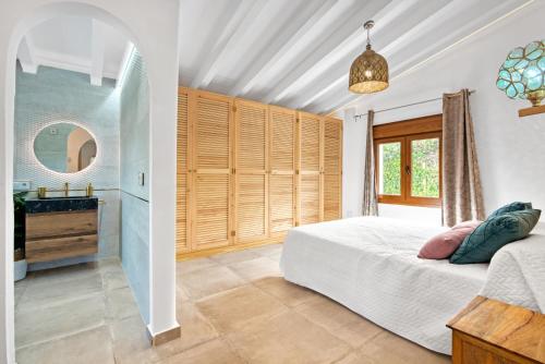 a bedroom with a bed and a sink and a mirror at Ca Rulleta Jávea in Jávea