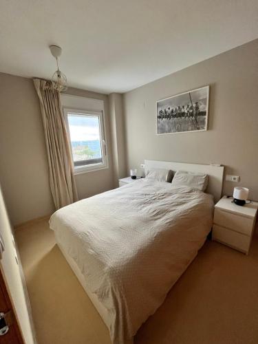 Un dormitorio con una gran cama blanca y una ventana en Las Terrazas De La Torre Golf en Roldán