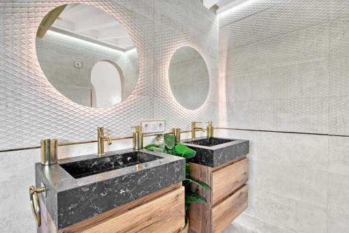 a bathroom with two sinks and two mirrors at Ca Rulleta Jávea in Jávea