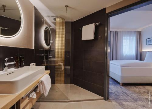 łazienka z umywalką i łóżkiem w pokoju w obiekcie Dorint Hotel Würzburg w mieście Würzburg