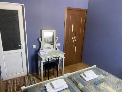 a bedroom with a bed and a mirror and a table at Hillside Guesthouse in Borjomi