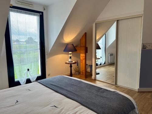 a bedroom with a bed and a large mirror at 305 - Belle maison à deux pas de l'Anse du Croc in Frehel