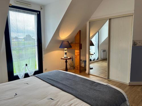 a bedroom with a bed and a large mirror at 305 - Belle maison à deux pas de l'Anse du Croc in Fréhel
