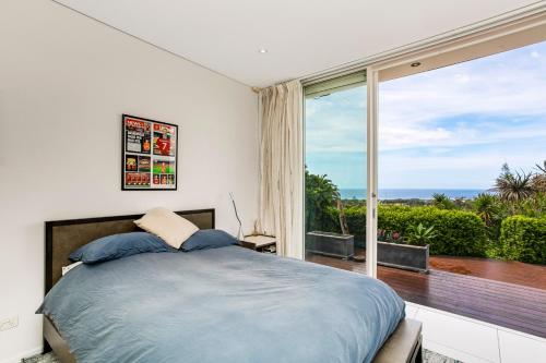1 dormitorio con cama y ventana grande en Pure Magical Views - Ocean Views en Deewhy