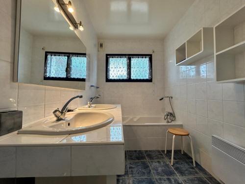 a bathroom with a sink and a tub and a mirror at 305 - Belle maison à deux pas de l'Anse du Croc in Fréhel