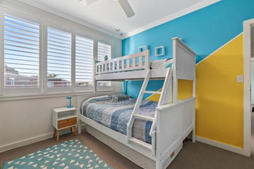 1 dormitorio con litera y paredes azules en The Eagles Nest Great Position, en Deewhy