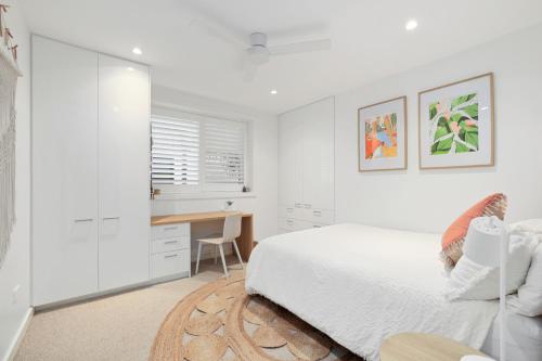 a white bedroom with a bed and a desk at Freshwater Villa - Seconds to the Beach in Freshwater