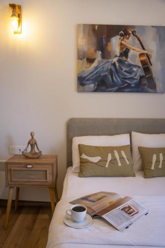 a bedroom with a bed with a book and a cup of coffee at Bir Dem Urla in Urla