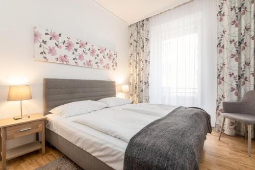 a bedroom with a bed and a chair and a window at Hotel Zentral in Wiener Neustadt