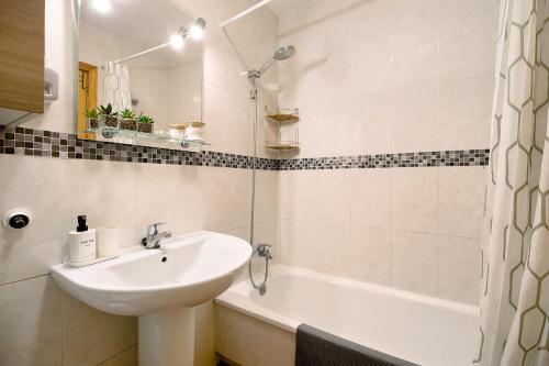 een witte badkamer met een wastafel en een bad bij leprince in Chiclana de la Frontera