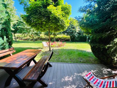 a wooden deck with a picnic table and two chairs at Pod Lipami in Lubiatowo